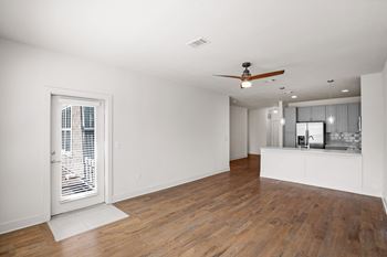A room with wooden floors and a ceiling fan. at Mirabelle Luxury Apartments, Kansas City